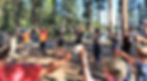 Child campers and staff wearing masks and holding hands in a circle with arms raised. 